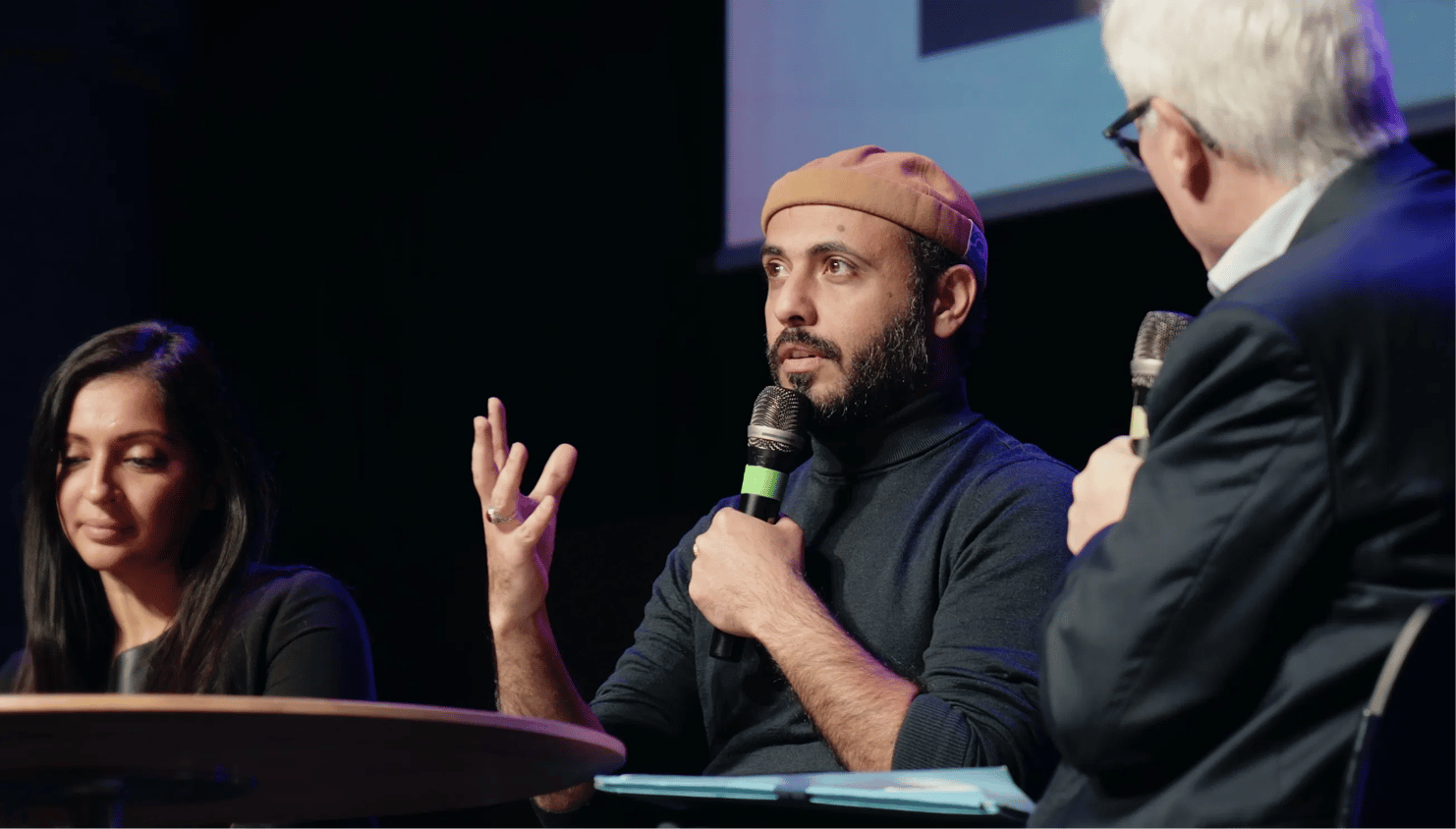 Table ronde lors d’un événement professionnel : un intervenant prend la parole au micro