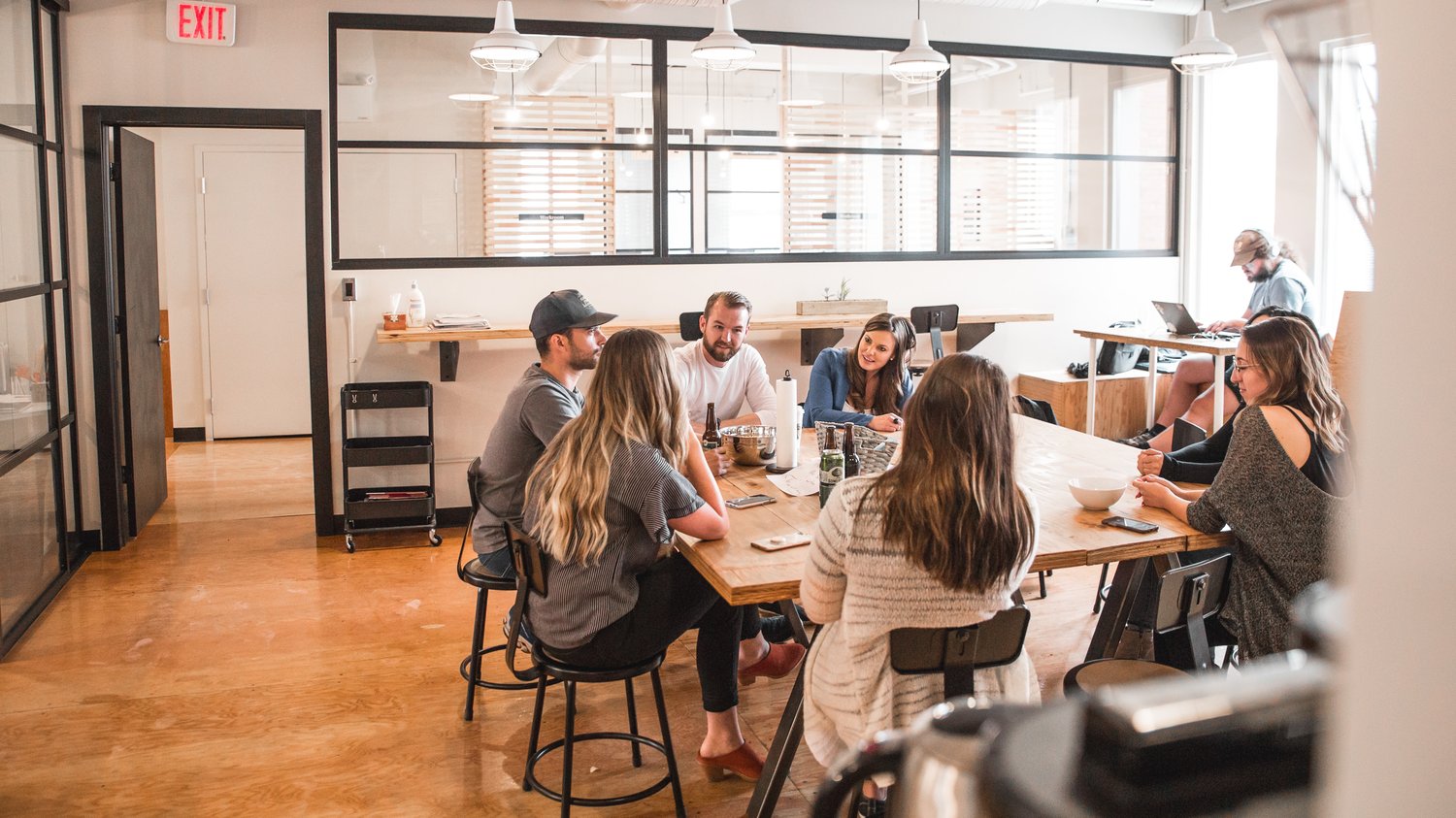 Équipe réunie autour d’une grande table dans un open space